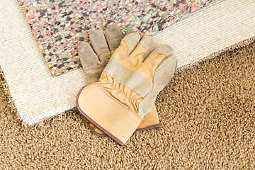 Image showing Gloves On Pulled Back Carpet and Pad In Room