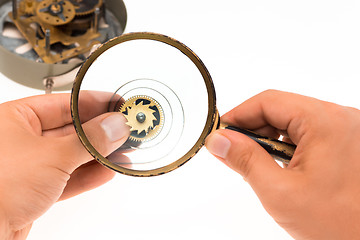 Image showing The male hand with magnifier and clockwork