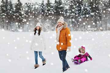 Image showing happy family with sled walking in winter forest