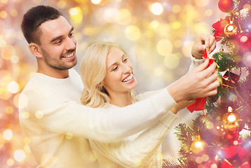 Image showing happy couple decorating christmas tree at home