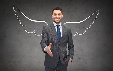 Image showing happy businessman with angel wings over gray