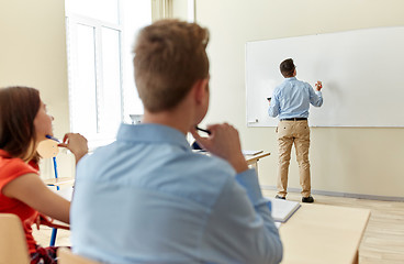 Image showing students and teacher writing on school white board