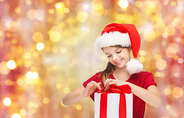 Image showing smiling girl in santa hat with christmas gift