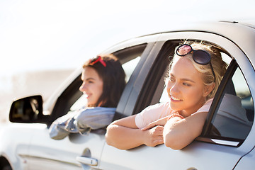 Image showing happy teenage girls or women in car at seaside