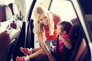 Image showing happy mother fastening child with car seat belt