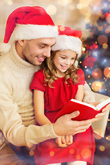 Image showing smiling father and daughter reading book