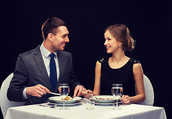 Image showing smiling couple eating main course at restaurant