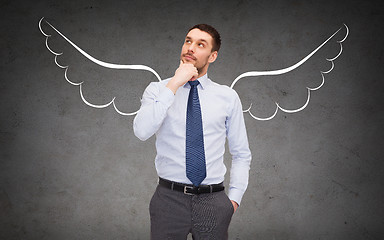 Image showing businessman with angel wings over gray