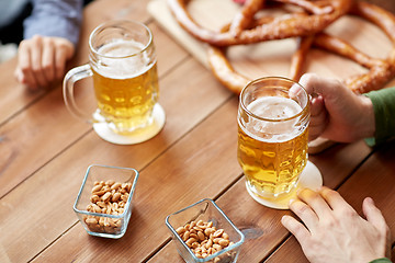 Image showing close up of hands with beer mugs at bar or pub