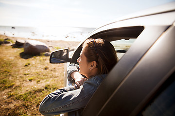 Image showing happy teenage girl or young woman in car