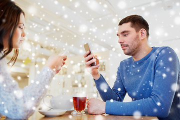 Image showing couple with smartphones drinking tea at cafe