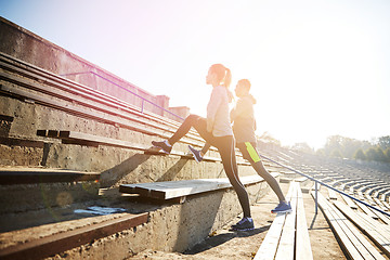 Image showing couple stretching leg on stands of stadium