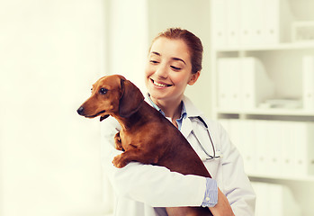 Image showing happy doctor with dog at vet clinic