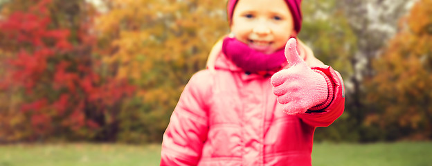 Image showing happy girl showing thumbs up over autumn park