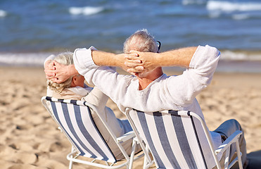 Image showing senior couple sitting on chairs at summer beach