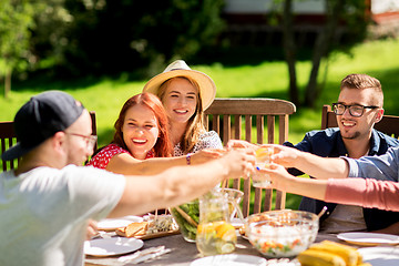 Image showing happy friends having dinner at summer garden party