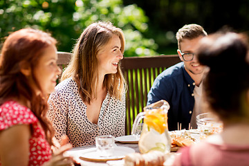 Image showing happy friends having dinner at summer garden party