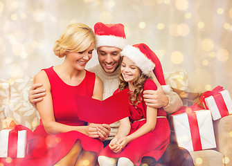 Image showing smiling family reading postcard