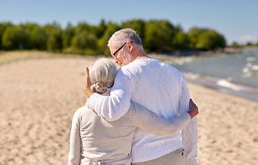 Image showing happy senior couple hugging on summer beach