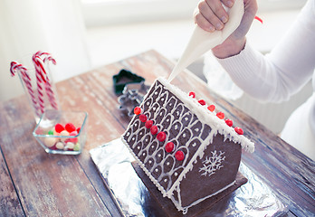 Image showing close up of woman making gingerbread houses