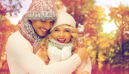 Image showing happy couple in warm clothes over autumn