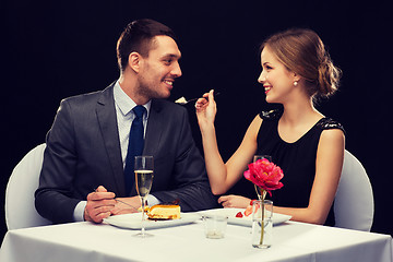 Image showing smiling couple eating dessert at restaurant