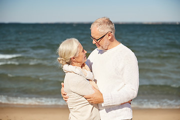 Image showing happy senior couple hugging on summer beach