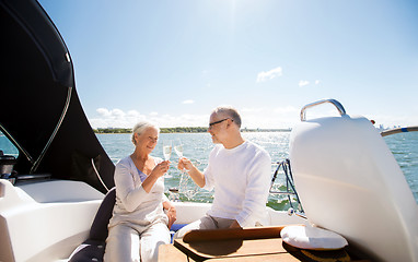 Image showing senior couple clinking glasses on boat or yacht