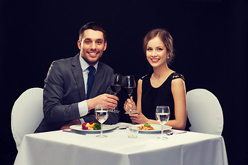 Image showing smiling couple eating main course at restaurant