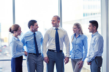 Image showing smiling business people talking in office