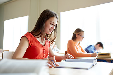 Image showing happy student girl with book writing school test