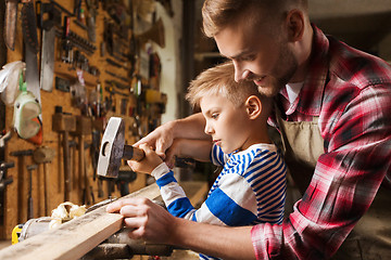 Image showing father and son with hammer working at workshop