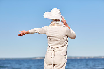 Image showing happy senior woman in sun hat on summer beach