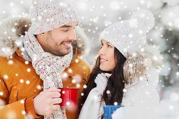 Image showing happy couple with tea cups over winter landscape