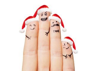 Image showing close up of hand with four fingers in santa hats