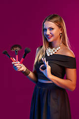 Image showing Woman makeup artist standing with brushes