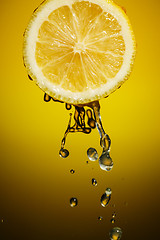 Image showing One half of lemon with fresh water drops isolated on colorful background