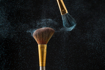 Image showing Make-up brushes with powder isolated on black background