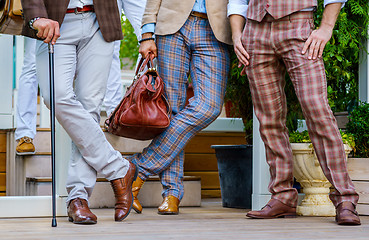 Image showing Stylish men in trendy suit with a walking stick and  leather valise stand on the terrace in summer