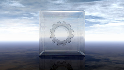 Image showing gear wheel in glass cube on reflective surface - 3d rendering