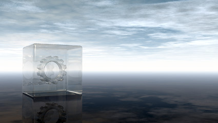 Image showing gear wheel in glass cube on reflective surface - 3d rendering