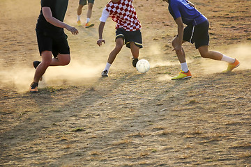 Image showing Young boys playing football game on the sunset