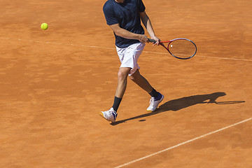 Image showing Male tennis player in action on the clay court on a sunny day