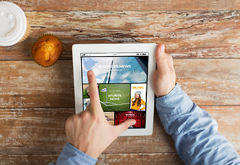 Image showing close up of hands with news page on tablet pc