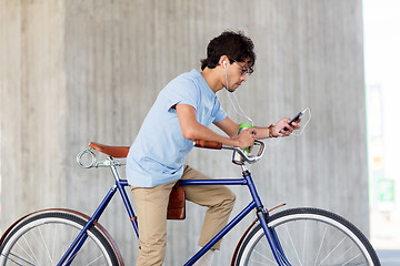 Image showing man with smartphone and earphones on bicycle