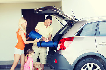 Image showing happy family packing things to car at home parking