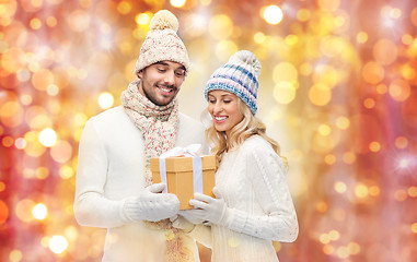 Image showing smiling couple in winter clothes with gift box