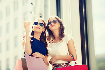 Image showing happy women with shopping bags outdoors