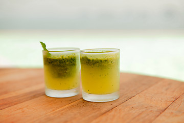 Image showing glasses of fresh juice or cocktail on beach