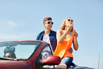 Image showing friends driving in car and blowing bubbles